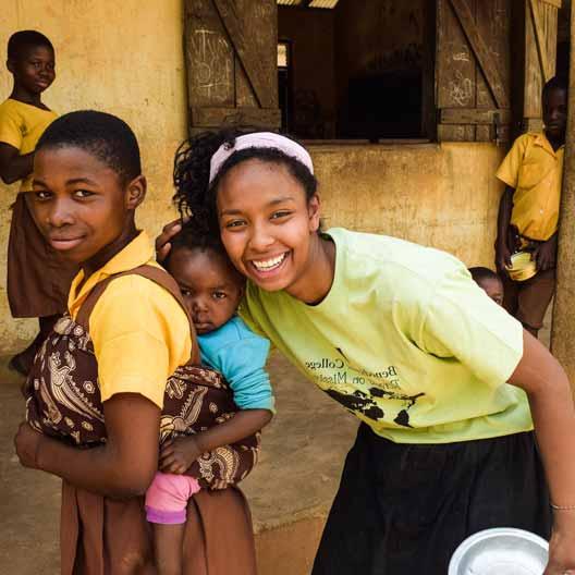 A Benedictine College student poses hugging a child in Ghana